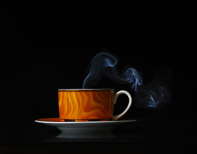 在黑色背景上热气腾腾的咖啡杯