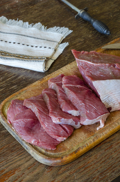 生牛肉片放在木砧板上。