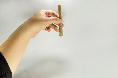 手里拿着一支东南亚本土香烟。
