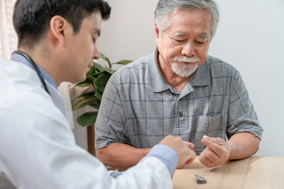 医生在家访后向老人讲解如何使用医疗信息