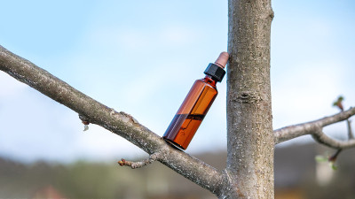 天然化妆品油瓶上的宏绿色植物。