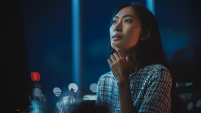 近距离人像金融分析师工作在计算机上与多显示器工作站与实时股票，商品和交易所市场图表。在投资机构工作的