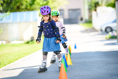 孩子们用圆锥体在学路上滑旱冰。