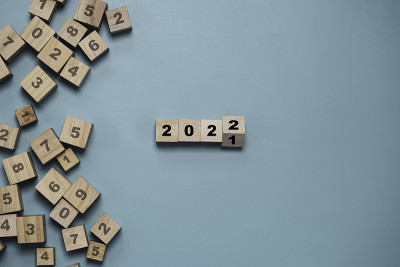木制方块翻转2021年到2022年，蓝色背景的方块上有其他数字，圣诞快乐，新年快乐，开始新的业务和计