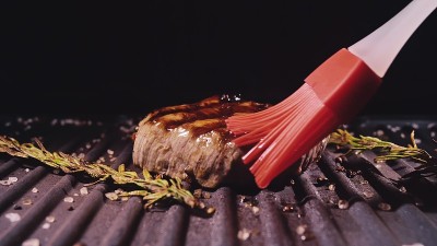 美味多汁的肉排烤制。上等的半熟烤牛肉。电炉，迷迭香，黑胡椒，盐。硅胶烹饪刷。