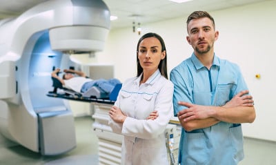 癌症治疗在现代医疗私人诊所或医院用直线加速器。在这名妇女接受癌症放射治疗时，专业的医生团队正在工作