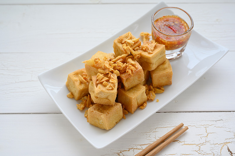 炸豆腐切成方形，放在盘子里