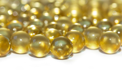 黄色鱼油胶囊，白色背景。Omega3型维生素特写。胶囊鱼油宏。维生素对健康。