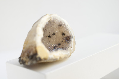 天然矿物玛瑙底。特写照片。米色结晶，带有黑色小夹杂物。