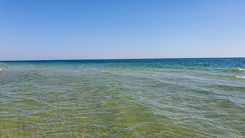 海景。碧蓝的水，浪花在岸边泛起泡沫。有选择性的重点。夏天休息。