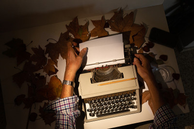 Top view of man's hands on a typewriter with autum