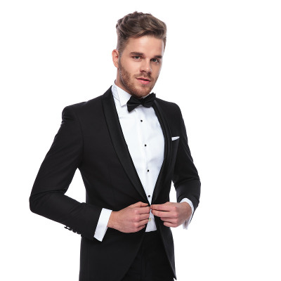 年轻优雅的男人扣他的礼服