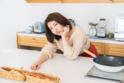 漂亮的亚洲女人在厨房做饭，担心