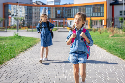 小女孩，小学生背着书包离开学校。
