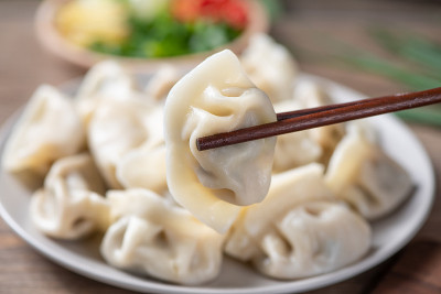 快来看看新鲜的水饺。中国食物在乡村古老的木制背景。