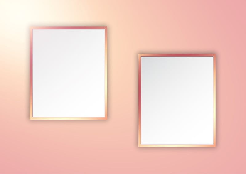 Rose gold picture frames on spotlit wall