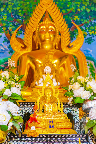 泰国苏梅岛Wat Plai lam寺庙内的金色佛像和多彩的佛教绘画和艺术