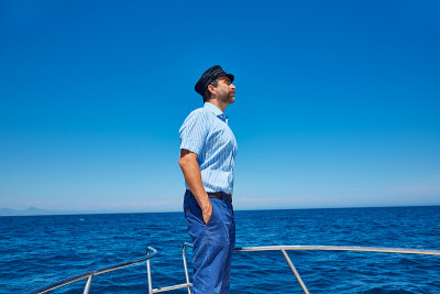 胡子水手帽男人在一艘小船上航行大海