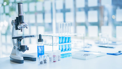在实验室里观察透明溶液的试管的医学或科学研究者或男医生