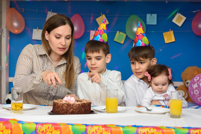 妈妈和她的孩子们一起切生日蛋糕