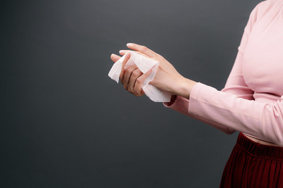 亚洲妇女用婴儿擦手纸或毛巾清洁她的脏手。成年妇女用白色湿纸巾清洁她的手。医疗保健，卫生和美丽的概念在