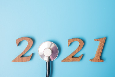 2021年，祝医疗保健、健康和医疗理念新年快乐。听诊器和木质号码在蓝色背景上