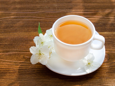 木桌上放着一杯茉莉花茶。特写，俯视图