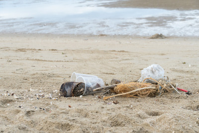 Plastic and garbage on dirty beach.