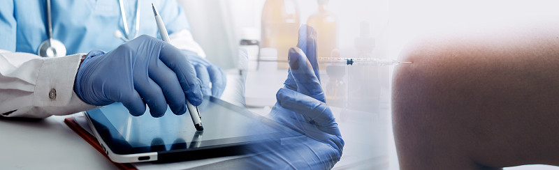 在实验室、微生物学和药学研究、医疗和保健中，医生和疫苗注射器注射流感疫苗。