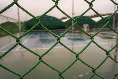 雨天围栏后面空荡荡的网球场