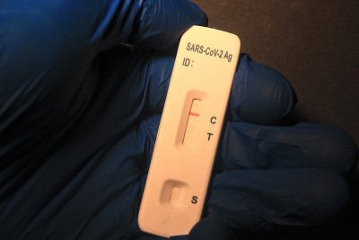 covid - sars-cov-2检测阴性，一只手戴着蓝色手套。