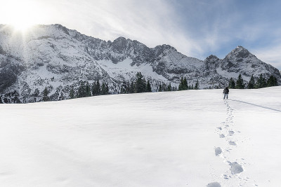 冬天的山和人在雪中行走。脚步在雪地