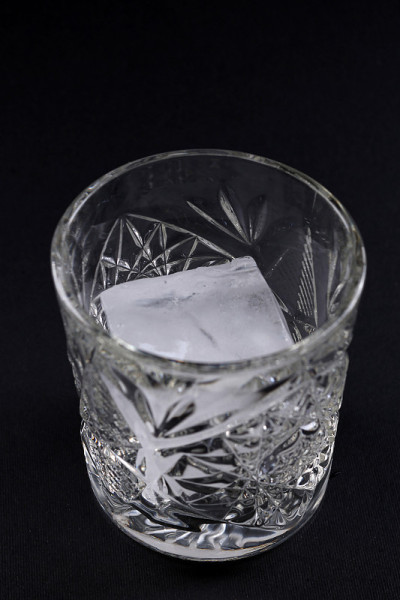 深色背景上加冰的玻璃杯。近距离