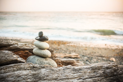 Inukshuk Cairn在海滩上的浮木上