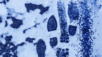 冬天雪地里肮脏的脚印。靴子在路上的踪迹