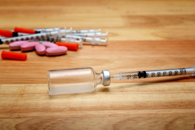 木桌上放着医用注射器和药瓶