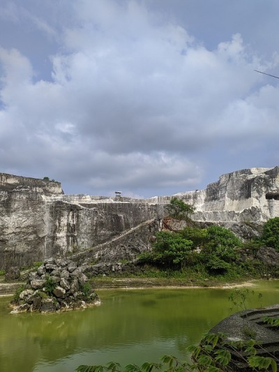 白色的砖采石场和流行的背景与石灰岩悬崖和在池塘里划船的照片。