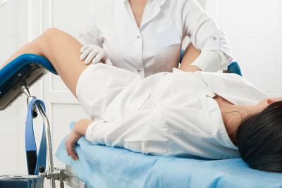 裁剪全景的妇科医生检查病人谁是坐在妇科椅子上。女性健康概念