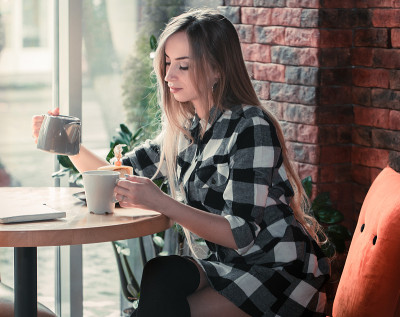 美丽的女孩正在咖啡厅喝茶