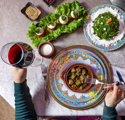 Woman eating Dolma, with red wine