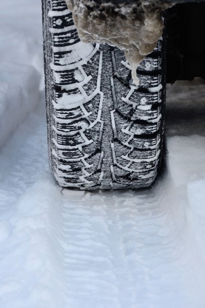 冬季汽车轮胎的特写与痕迹和图案的雪地