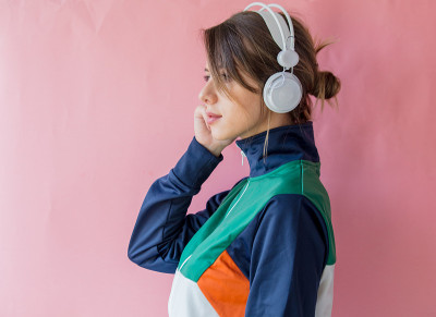 年轻女子穿着90年代风格的衣服，戴着耳机
