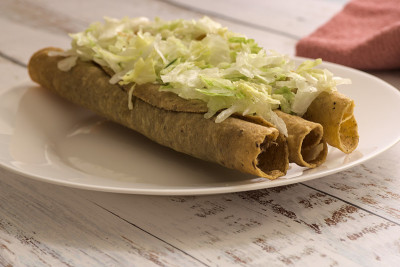 传统的墨西哥食物，金色的肉玉米饼(flautas)配红酱。