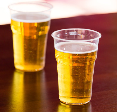 桌上放着塑料杯里的新鲜啤酒