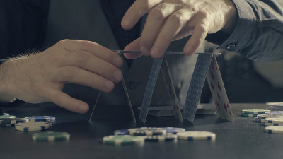 人的手用纸牌盖房子