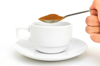 手持茶匙和速溶咖啡倒
