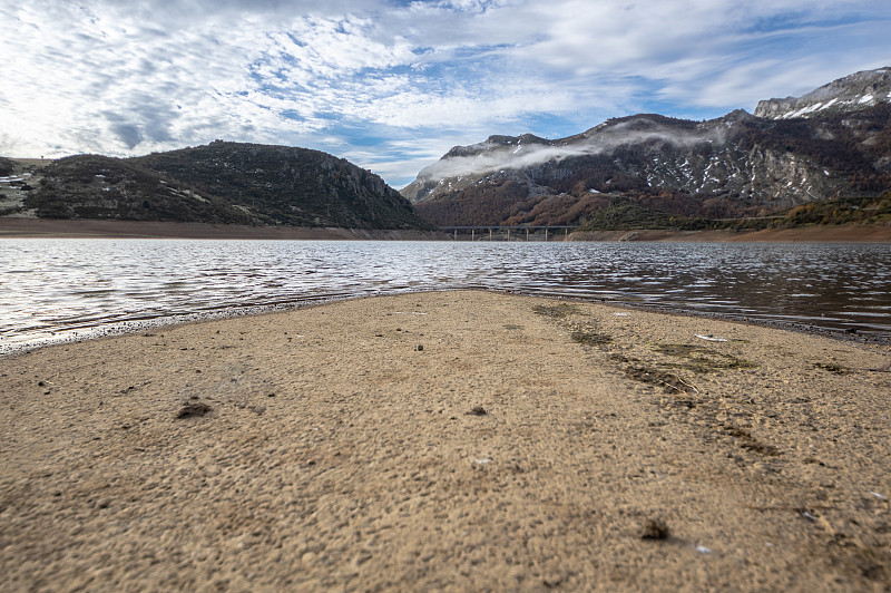 在西班牙里昂Riaño水库的水通常淹没在废墟中的旧道路。在背景中，你可以看到晨雾之间的群山。