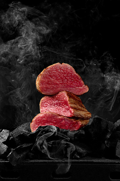 在炭火上切上稀有的小牛肉里脊，黑底白烟
