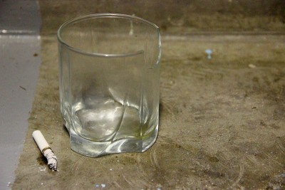 水泥地上有空的碎玻璃和烟头。社会问题酗酒有害习惯