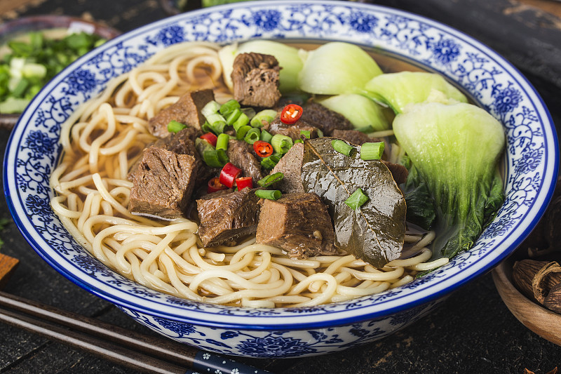 麻辣红汤牛肉面放在木桌上的碗里